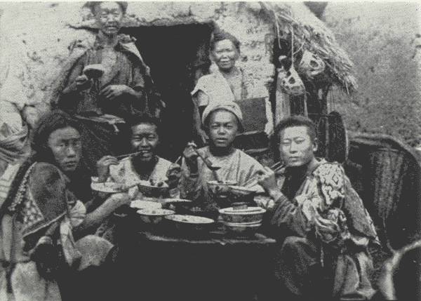 A REAL ABORIGINAL FEAST

The man on the left scowled in anger as the Author snapped his
picture—otherwise, all were happy. For them an exceptional feast, not an
everyday affair.