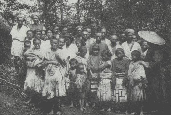 FAR FROM THE MADDENING THRONG

Regimenting the whole village to bid a sad farewell; Samuel Pollard,
author's traveling companion on this trip in the wilds, stands under the
hat on the right.