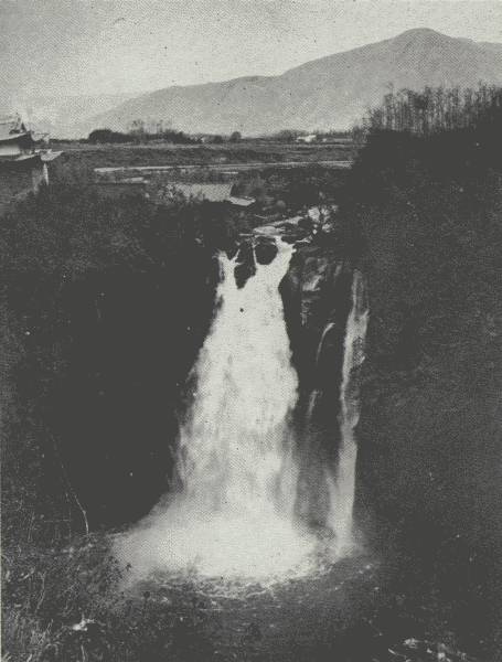 THE TENGYUEH WATERFALL

Mountains opposite are about 4,000 feet higher than the Tengyueh Plain,
which is about 5,500 feet; over this waterfall one of author's ponies
"committed suicide," Chinese said.
