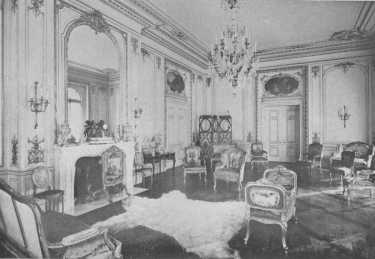 The mantel with its great glass reaching to the cornice,
the wall panels, paintings over the doors, and beautiful furniture, all
show the spirit of the best Louis XV period. The fur rug is an
anachronism and detracts from the effect of the room.