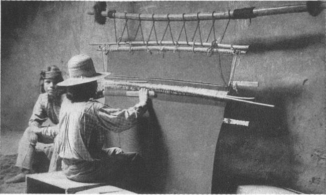 Copyright by H. S. Poley

A Hopi Indian weaving a rug on a hand loom in a deserted cave