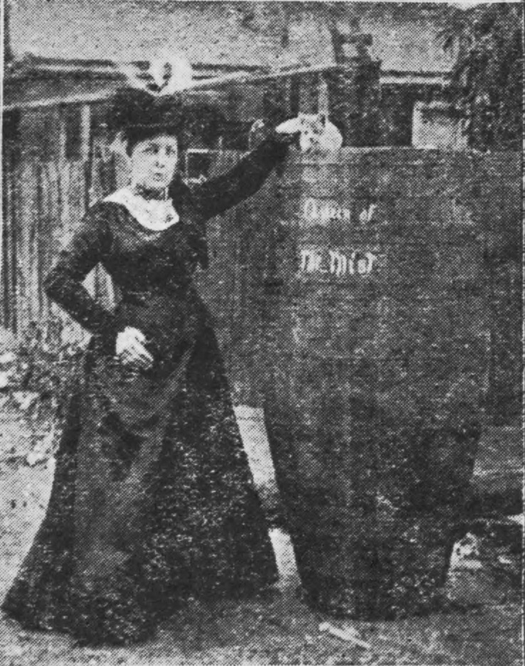 Photo of Annie Edson Taylor standing next to her barrel.